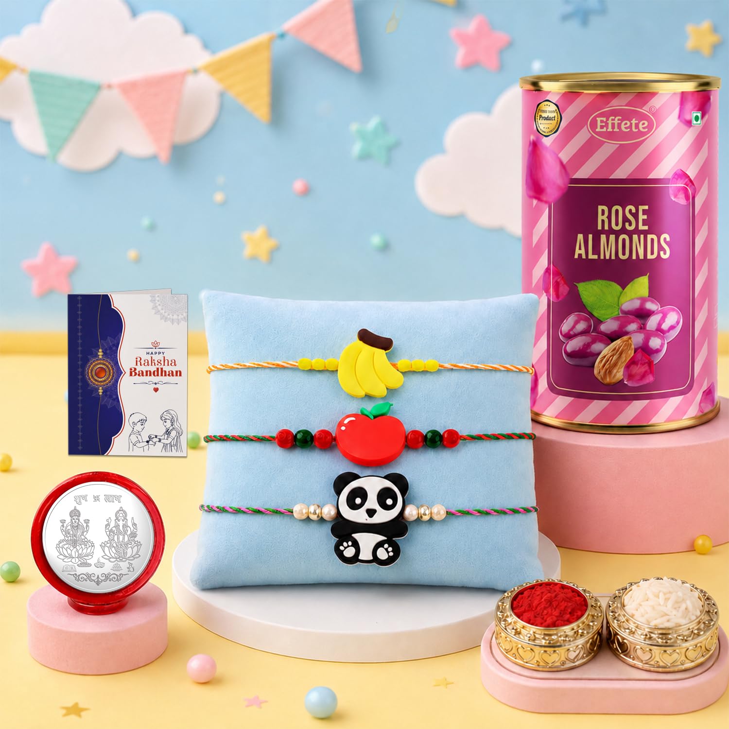 A Rakshabandhan gift set with a blue pillow holding three bracelets, a pink tin of rose almonds, a small silver coin, and