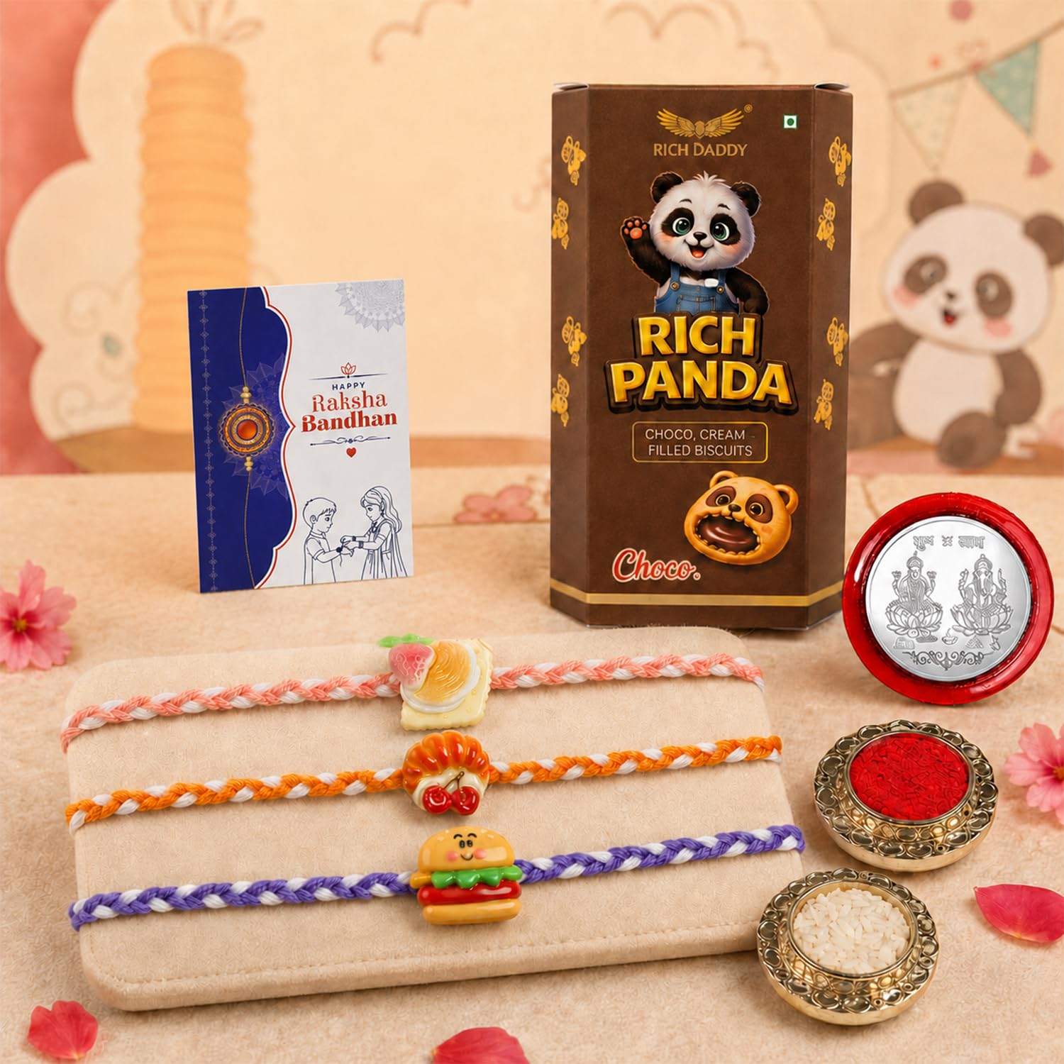 A brown box of Rich Panda biscuits stands next to a blue Raksha Bandhan card, three food-themed Rakhis, and two small bowls