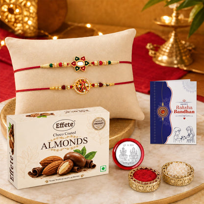 Two ornate red and gold bracelets with decorative centers rest on a light brown pillow, with a box of chocolate almonds and