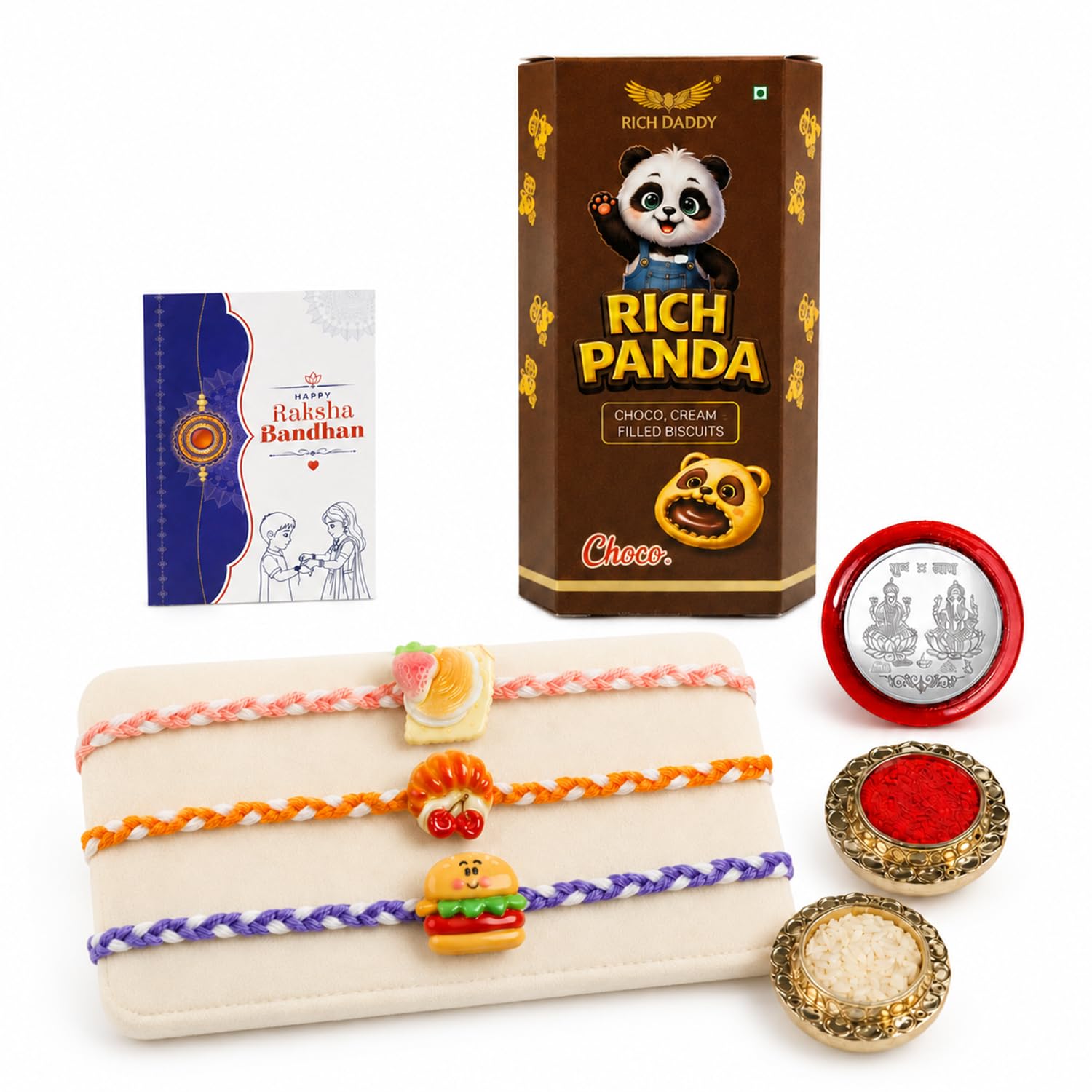 A brown box of Rich Panda biscuits, a blue Raksha Bandhan card, three food-themed Rakhis, and two small bowls of red and
