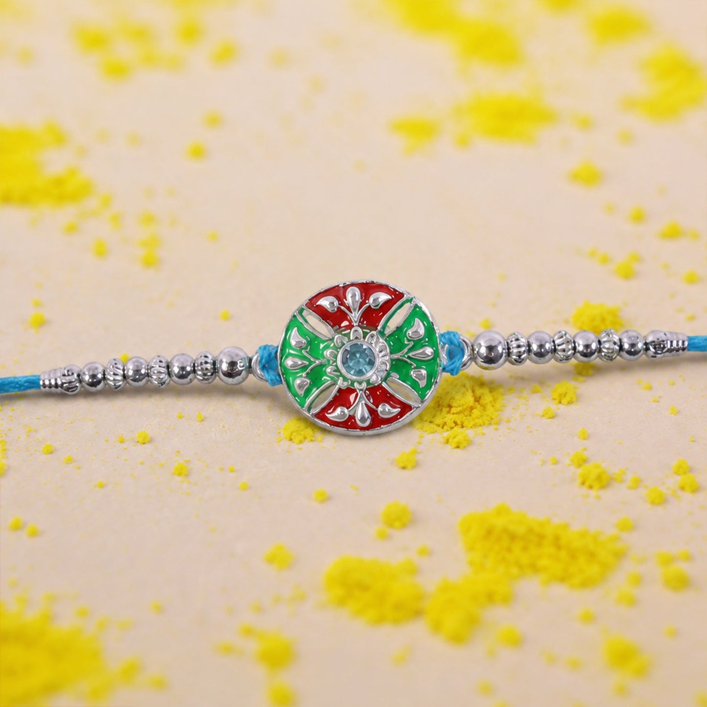 Close-up of blue thread rakhi with multicolor center and decorative beads