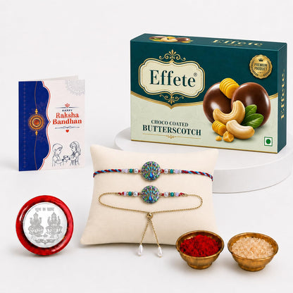 A Raksha Bandhan gift set includes a teal box of butterscotch, a greeting card, two peacock-themed bracelets, and small