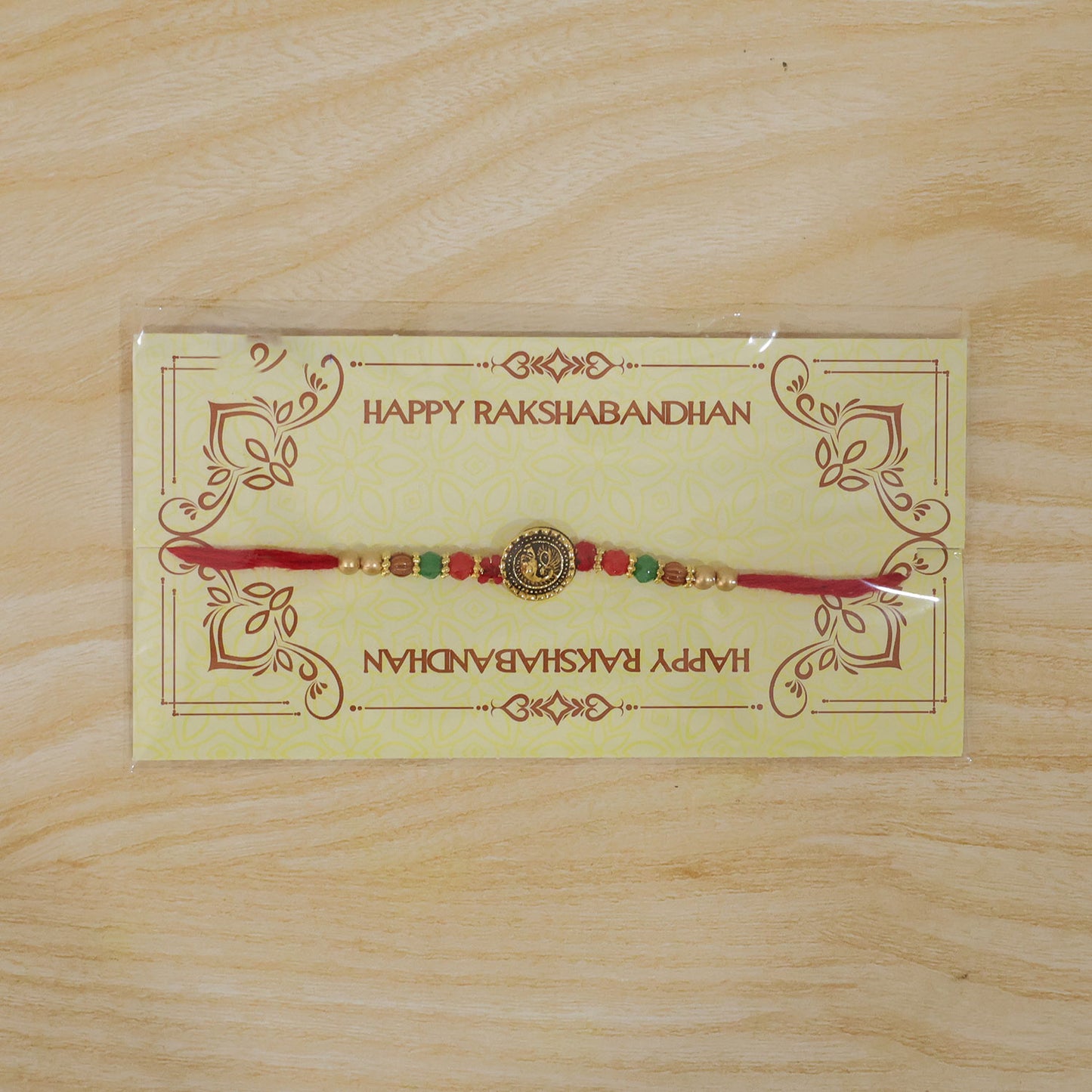 Ganesha Golden Medallion Devotional Rakhi with Red Green Beads and Festive Thread