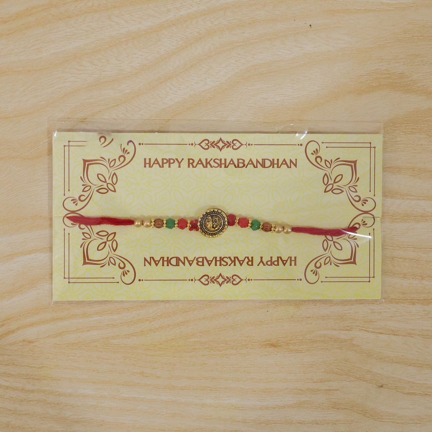 Ganesha Golden Medallion Devotional Rakhi with Red Green Beads and Festive Thread