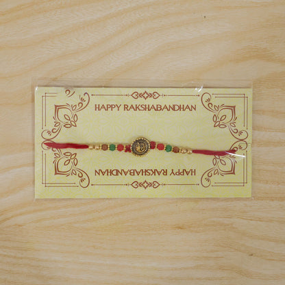 Ganesha Golden Medallion Devotional Rakhi with Red Green Beads and Festive Thread