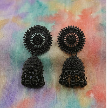 A pair of black oxidised jhumka earrings with a round stud and bell-shaped drop featuring small beads.