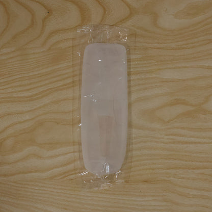 A translucent white silicone remote cover is sealed in clear plastic packaging on a light wooden surface.