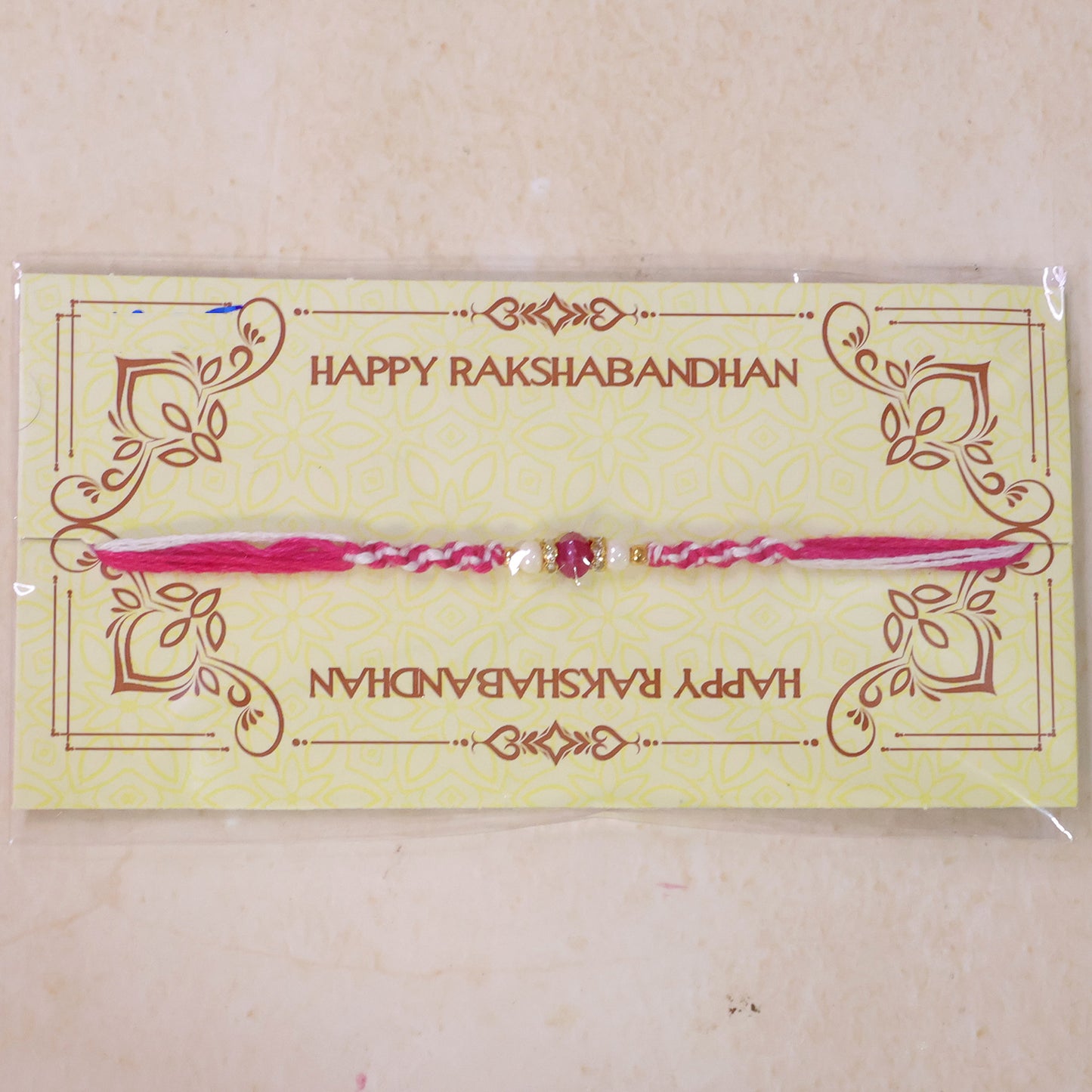 Pink-White Braided Rakhi with Rose-Pink Stone Bead Pendant