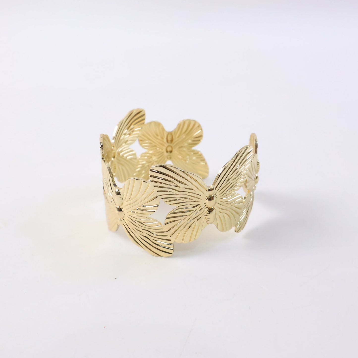 Artistic flower design gold bracelet laid flat