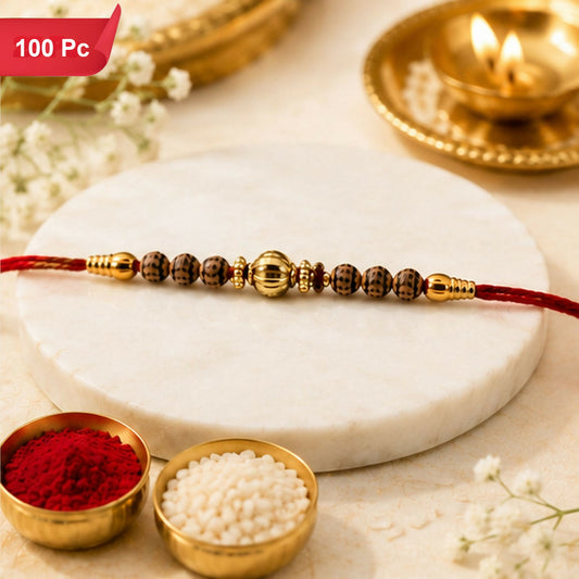 A red thread bracelet with brown patterned beads and a central gold-colored bead is displayed on a white marble slab with