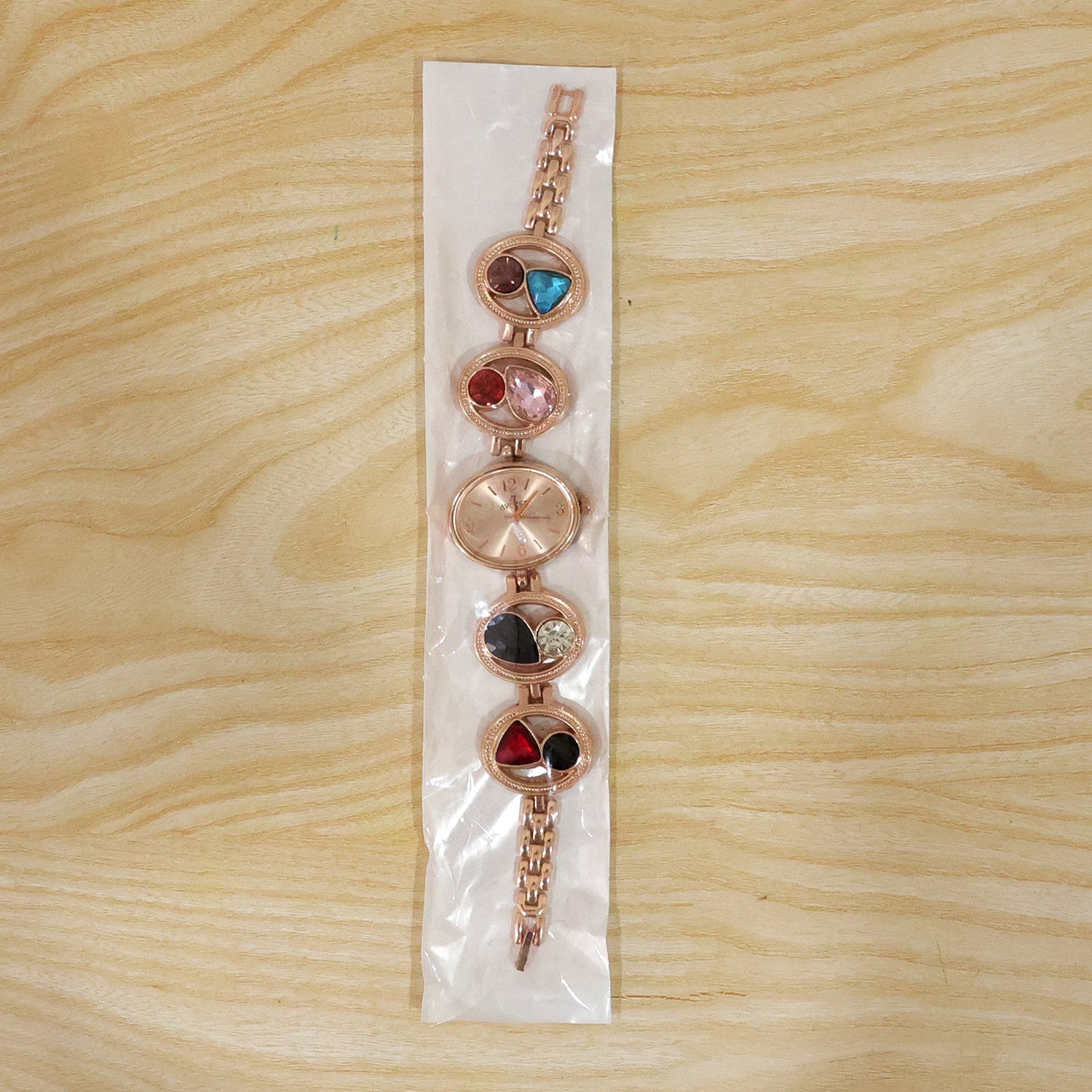 Detail of the watch clasp and intricate rose gold bracelet pattern.