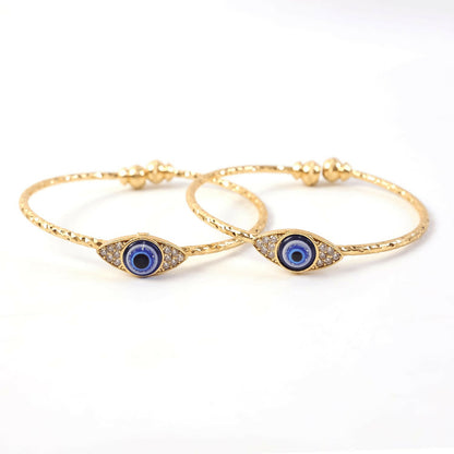 Gold evil eye bangle worn on wrist highlighting design and fit