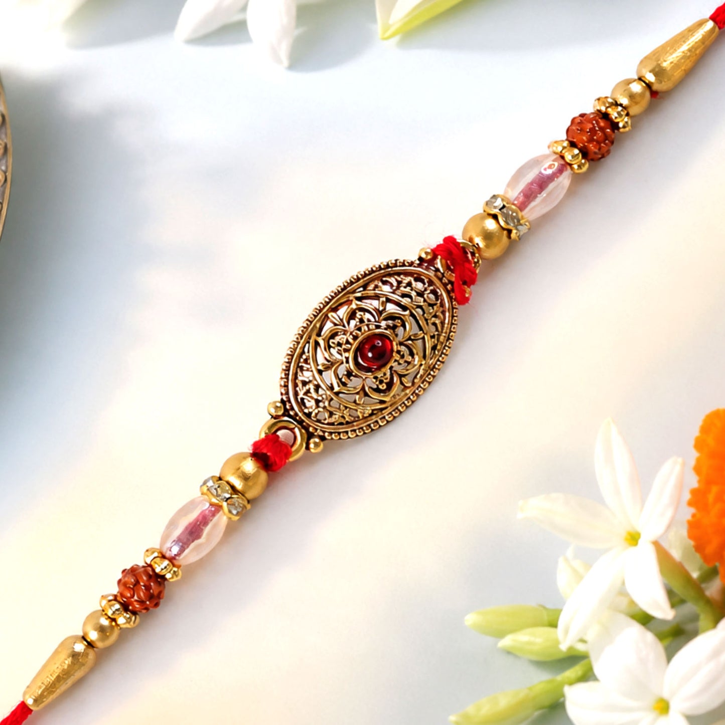Oxidized Gold Oval Pendant Rakhi with Red Stone and Rudraksha Beads