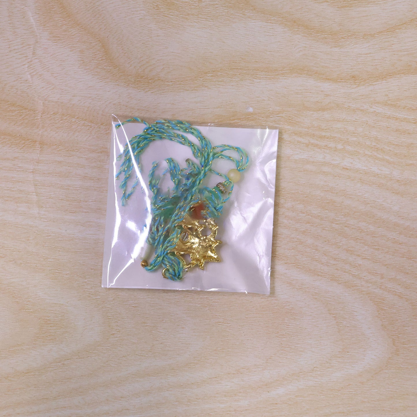 Sacred Nariyal Kalash Golden Metallic Motif Rakhi with Sea Green & Coral Beads