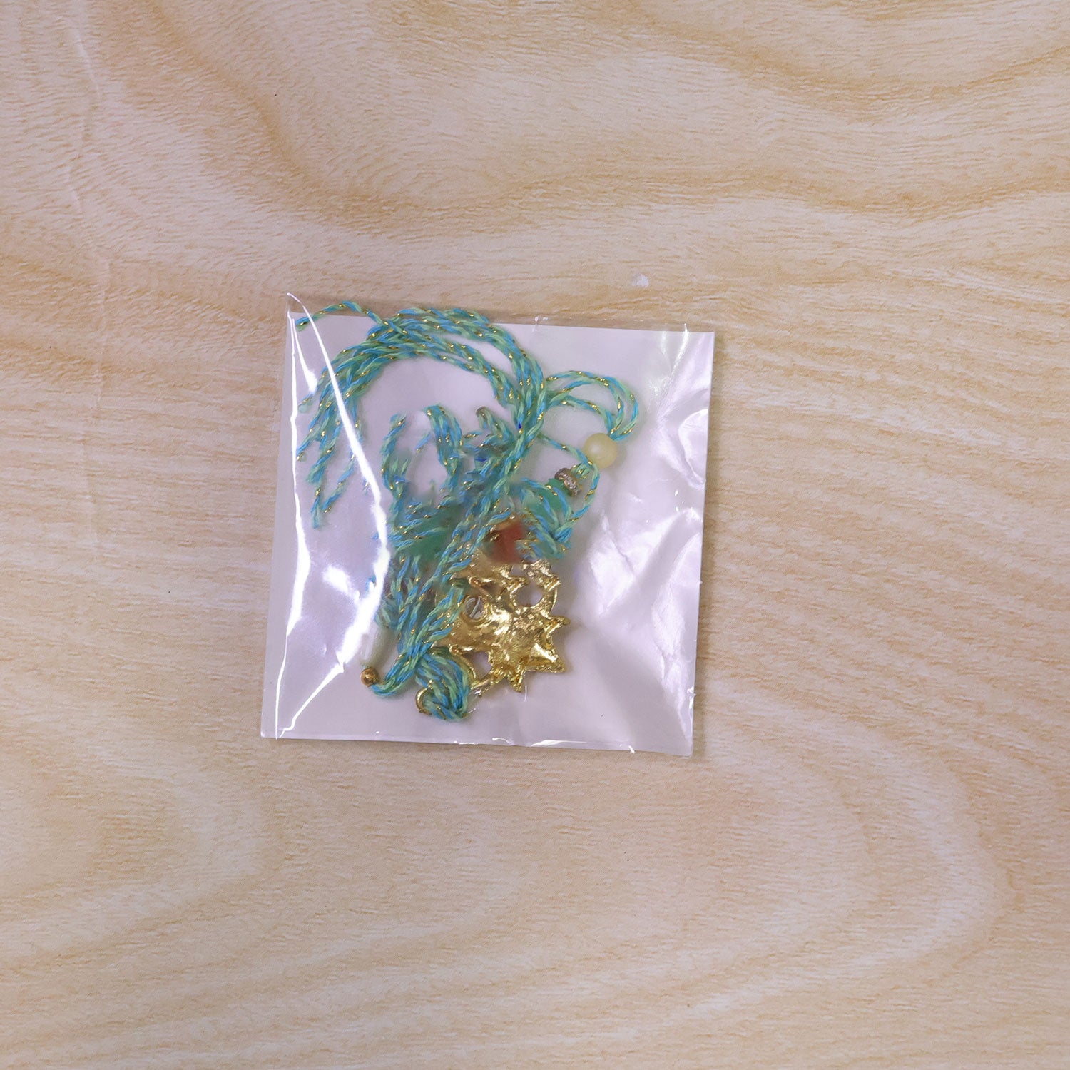 Sacred Nariyal Kalash Golden Metallic Motif Rakhi with Sea Green & Coral Beads