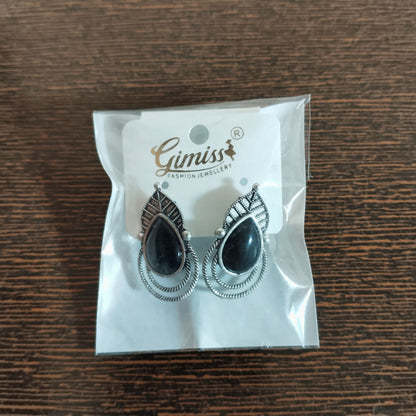 Vintage black teardrop earrings with twisted rope borders on white background