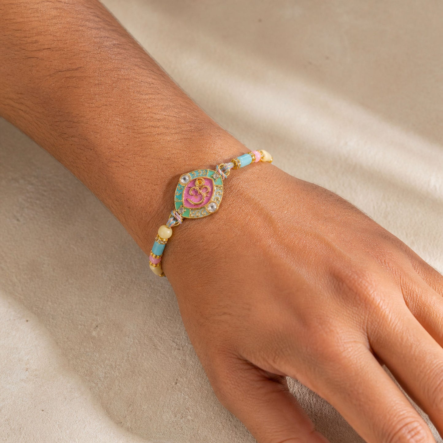 Turquoise Om Pendant Rakhi with Pink Kundan and Pastel Beads