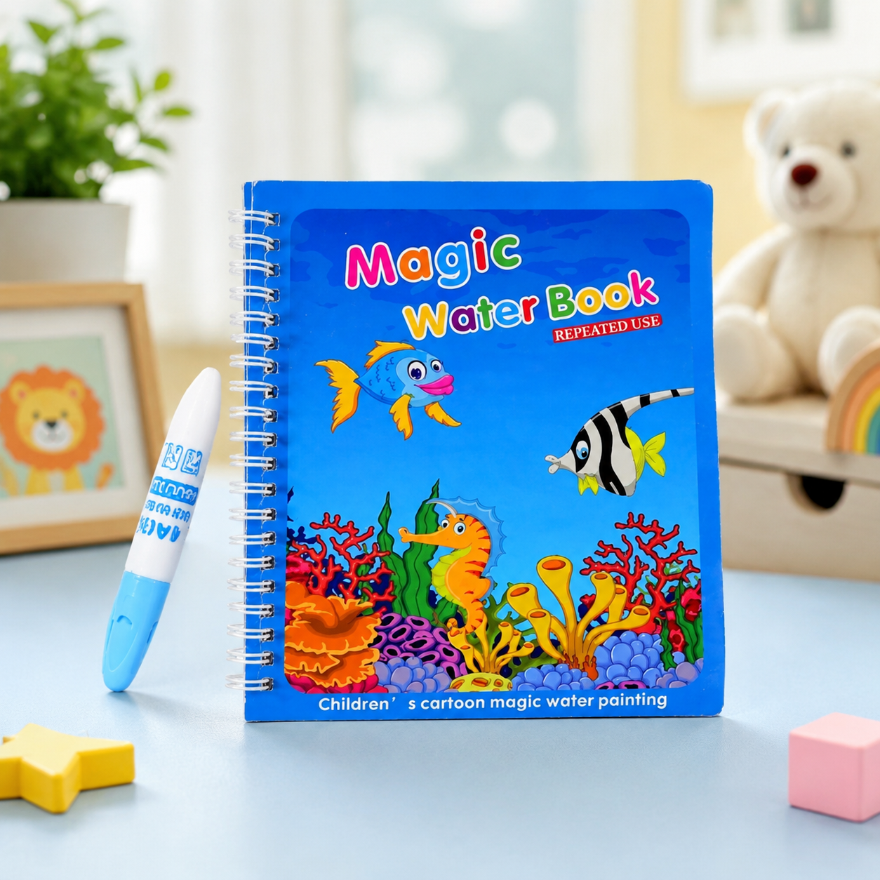 A blue spiral-bound 'Magic Water Book' with an underwater scene and a white water pen on a light blue table.