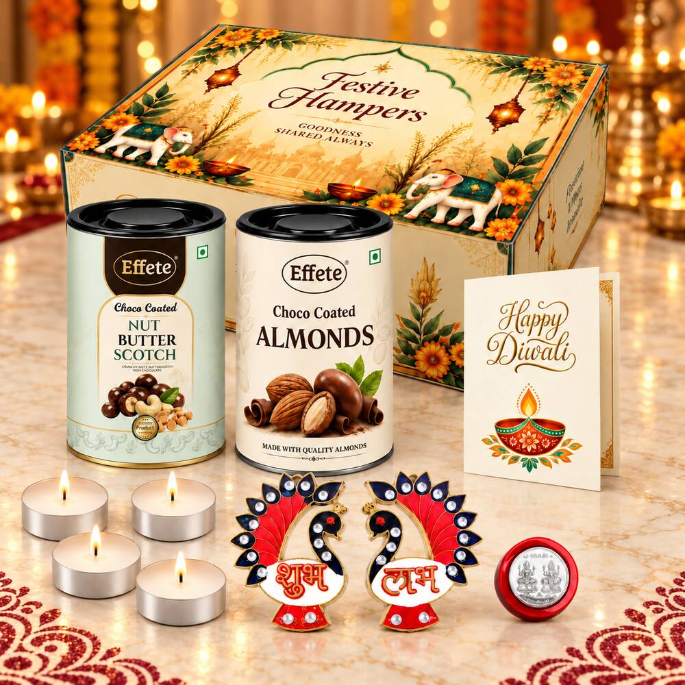 A Diwali gift hamper featuring two tins of nuts, four lit tealight candles, two decorative peacock Shubh Labh pieces, and a