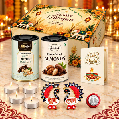 A Diwali gift hamper featuring two tins of nuts, four lit tealight candles, two decorative peacock Shubh Labh pieces, and a