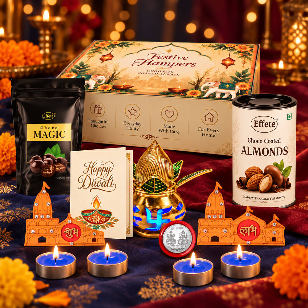 A festive Diwali gift hamper on a dark blue cloth with scattered orange flowers and warm background lights.