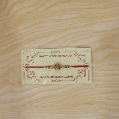 Om Damru Trishul Devotional Rakhi with Sparkling Stones and Brown Beads