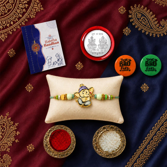Ganesha multicolor rakhi gift combo with decorative magnets and puja essentials.