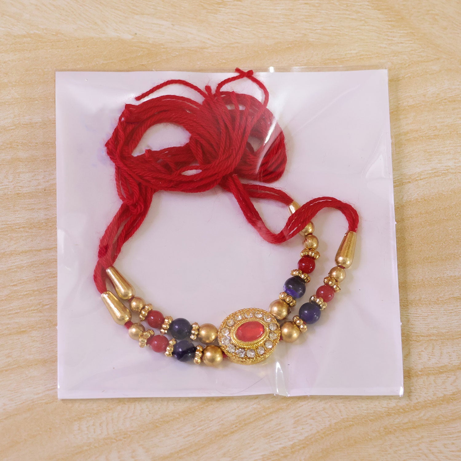 Red Blue Beaded Rakhi with Ruby Center and Rich Traditional Festive Gift Styling