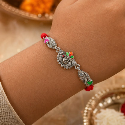 Silver-Toned Lord Ganesha Rakhi with Floral Design, Crystal Accents & Designer Red Thread