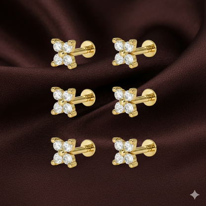 Close-up of gold plated flower stud earrings showcasing ruby center and sparkling halo