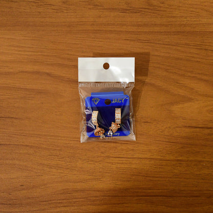 Gold-tone huggie drop earrings sparkling under light with elegant design
