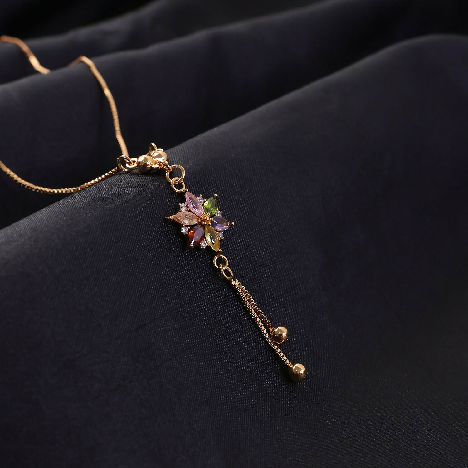 Side view of multicolor crystal flower pendant necklace with tassel
