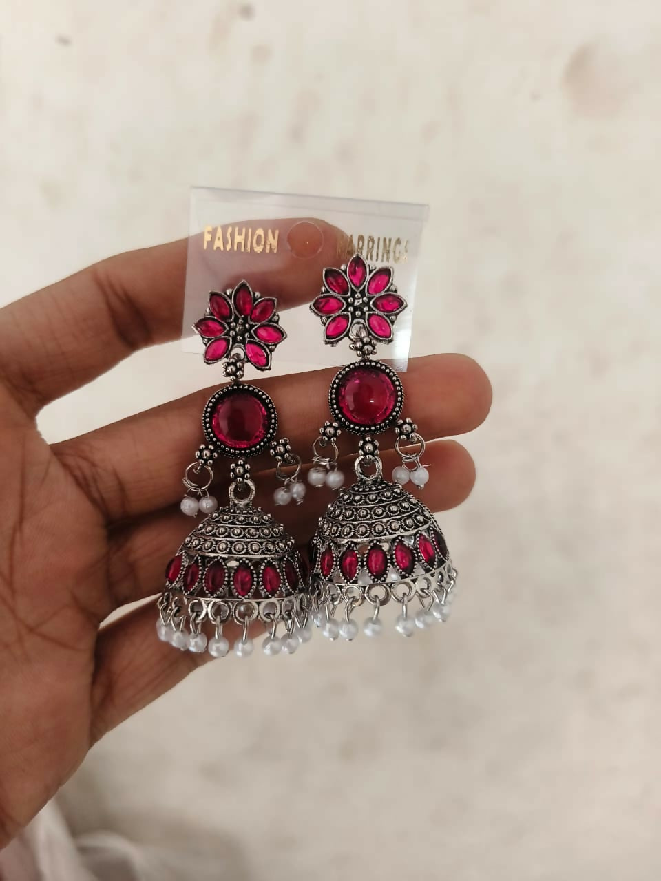 Model wearing traditional Indian oxidized Jhumkha earrings with pastel lilac stones