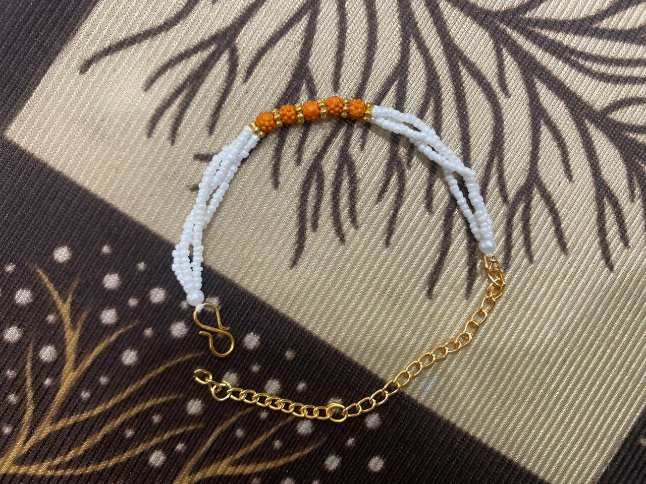 Lifestyle image of rudraksha bracelet with white pearl beads and gold details
