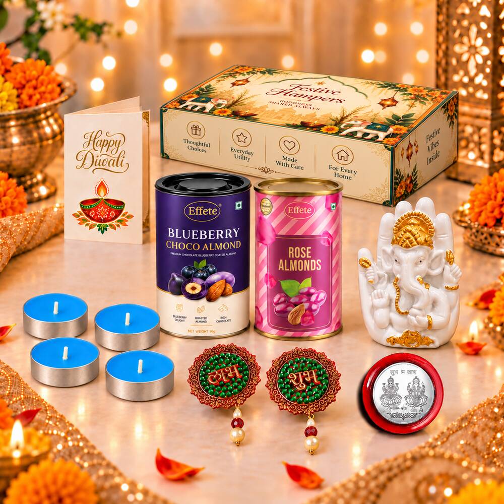 A festive Diwali hamper with a Ganesha idol, almond tins, tealights, and decorations on a gold-accented table with blurred