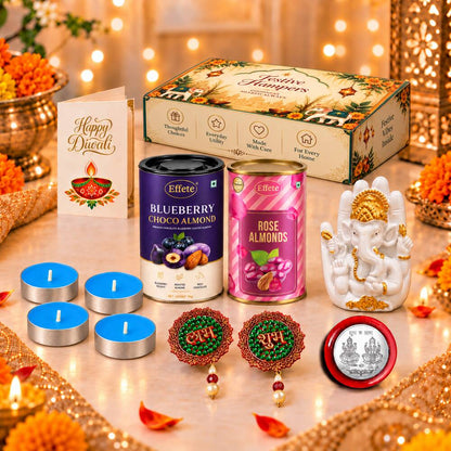 A festive Diwali hamper with a Ganesha idol, almond tins, tealights, and decorations on a gold-accented table with blurred