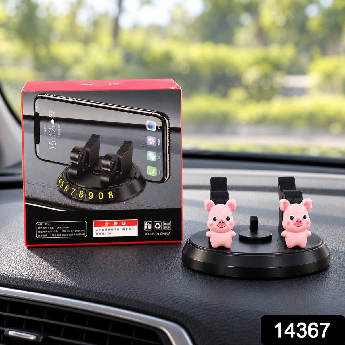 Black phone holder with two pink pig figurines and a red box on a car dashboard, displaying the number 14367.