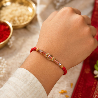 Red Braided Rakhi with Wooden Beads and a Pink Crystal Cylinder Bead