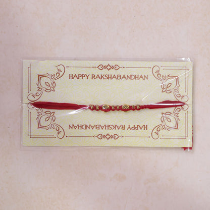 Red Braided Rakhi with a Row of Antique Gold Coin-Style Charms