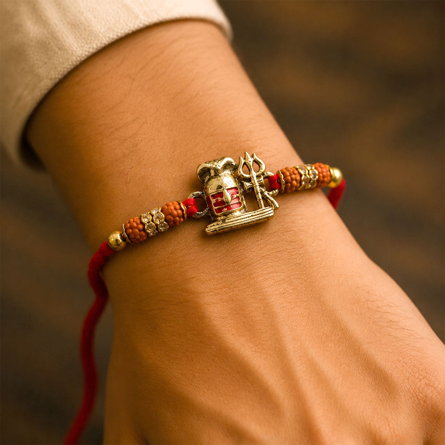 Shivling Trishul Devotional Rakhi with Golden Lord Shiva Centre and Orange Beads