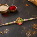 Textured Gold Om Pendant Rakhi with Leaf Accent and Pearl Beads