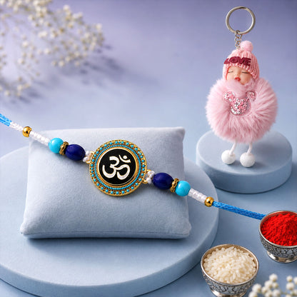 Round Om Stone Studded Enamel Rakhi with Cute Doll Keychain Combo (2 Pc)