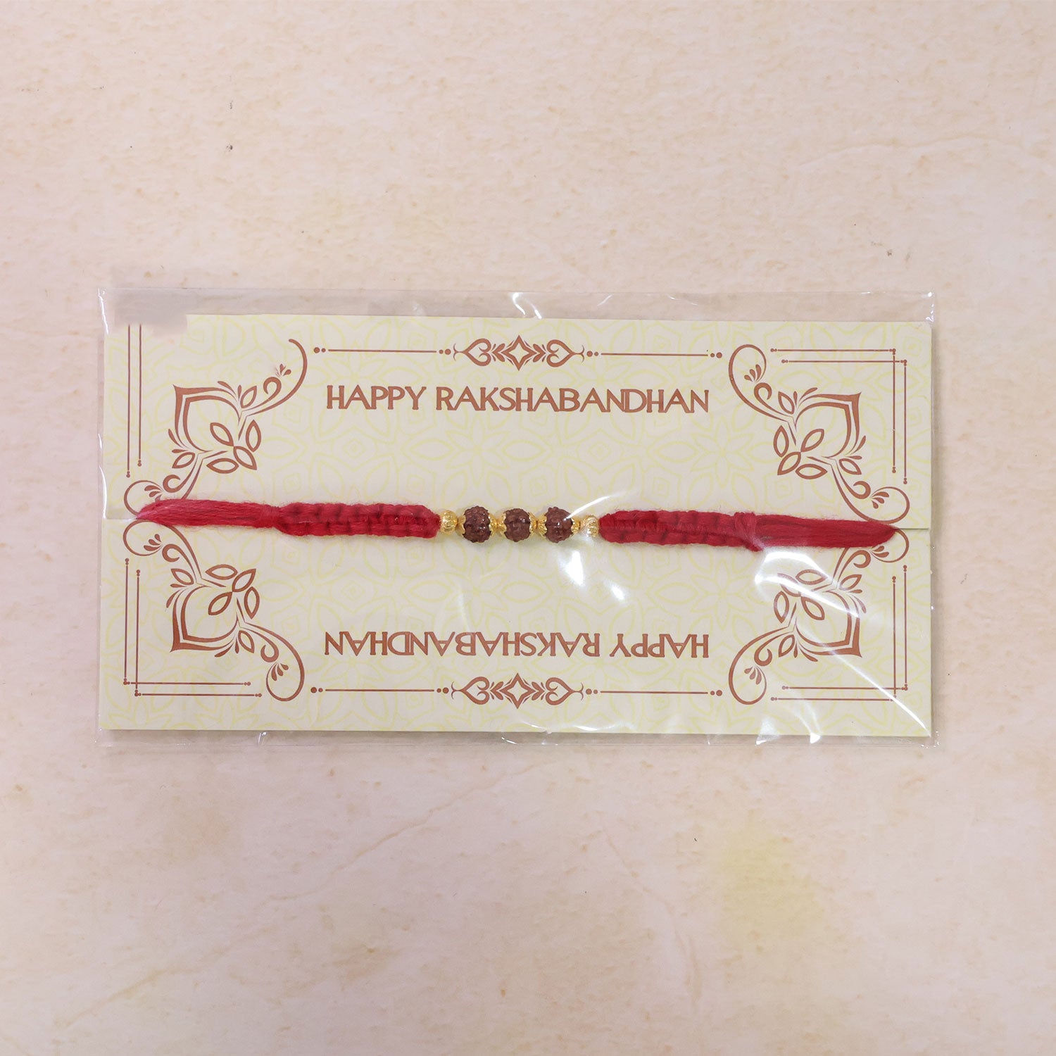 Red Braided Rakhi with Rudraksha Beads and Golden Bead Accents