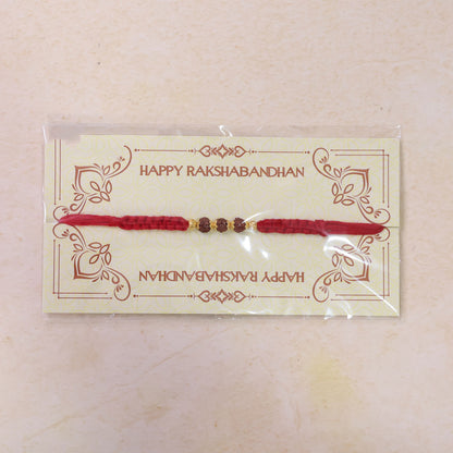 Red Braided Rakhi with Rudraksha Beads and Golden Bead Accents
