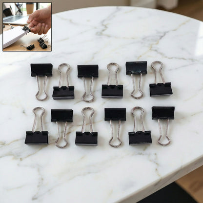 Stack of documents secured with black binder clip