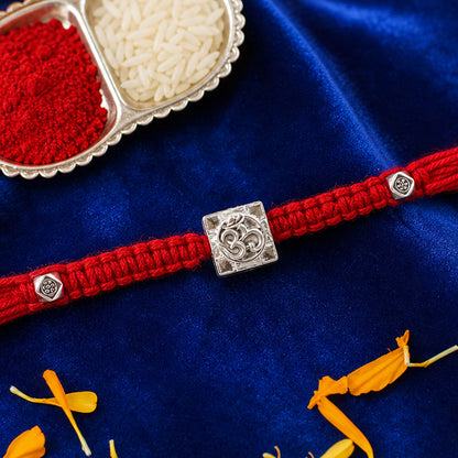Red Braided Rakhi with Silver Om Pendant Set in a Square Frame