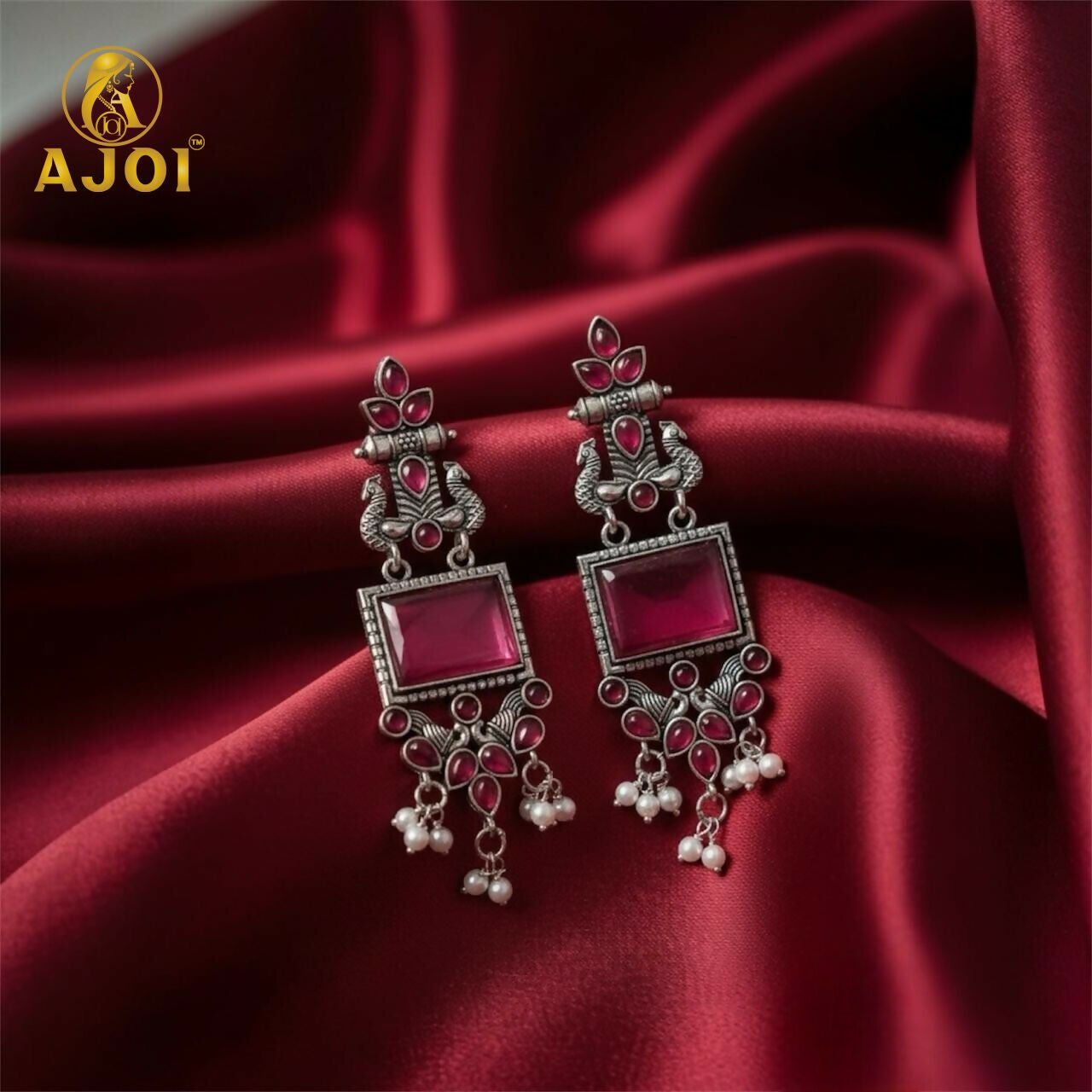 Side view of antique silver earrings with pink floral design