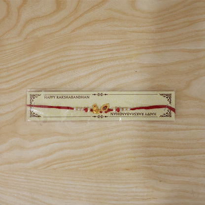 Krishna Mor Pankh Rakhi with Red Pearls and Festive Gold Charm