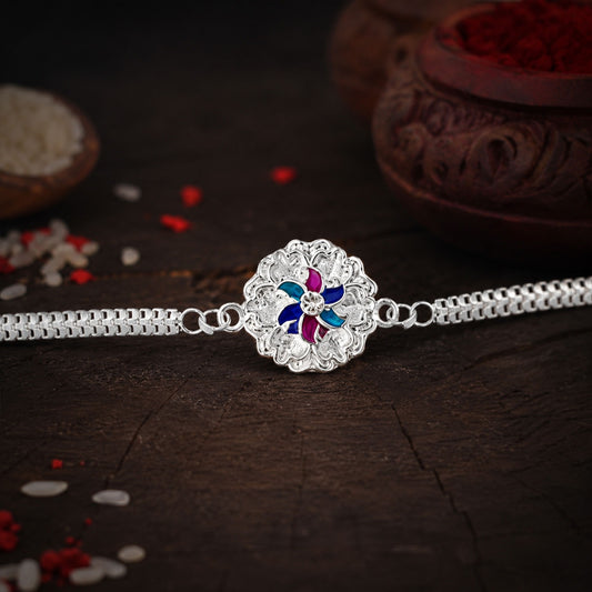 Elegant silver floral Rakhi with delicate enamel detailing and a dual chain design.