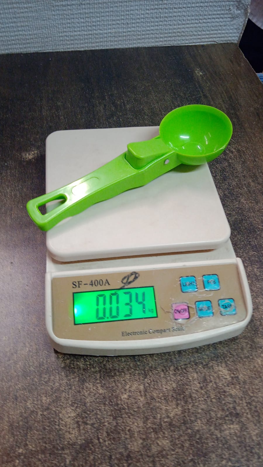 Green plastic ice cream scoop displayed vertically